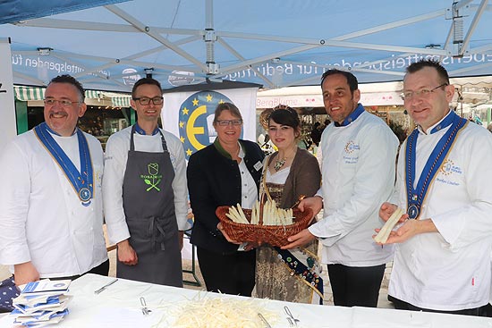 Spargelschäl Aktion von Euro-Toques Deutschland, zu der gut ein Dutzend Köche aus der Region auf dem Viktualenmarkt frisch gekauften Spargel schälten, hier zusammen mit der 1. Vorsitzenden des Spargelerzeugerverbandes und -ringes Südbayern Claudia Westner und der Schrobenhausener Spargelkönigin Lena I (©Foto: Martin Schmitz)